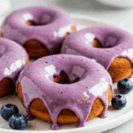 Blueberry cake donuts with purple glaze and fresh blueberries