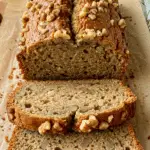 Zucchini bread slice showing moist texture with green zucchini flecks and walnuts