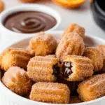 Air fryer churro bites with golden cinnamon sugar coating and chocolate dipping sauce